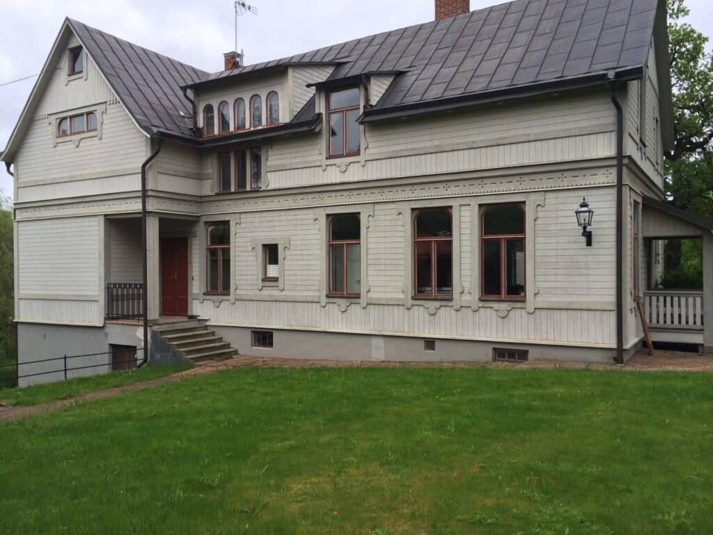 Renoverad villafasad med träpanel och klassisk veranda – renoveringsprojekt av G.F. Consulting